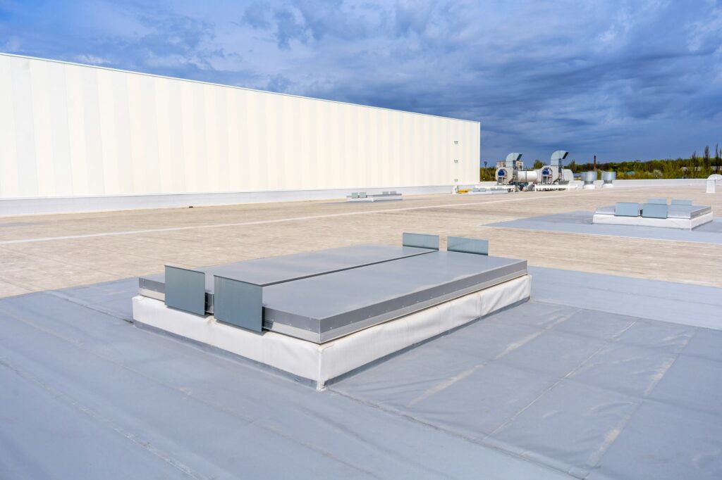 White metal sheet rooftop wall on commercial building with blue sky